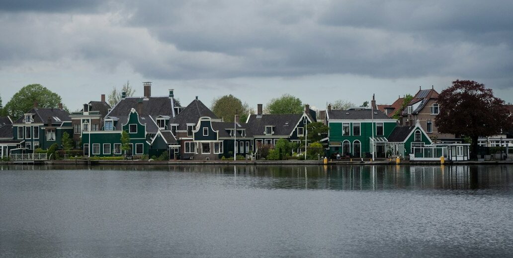 A body of water with houses in the background